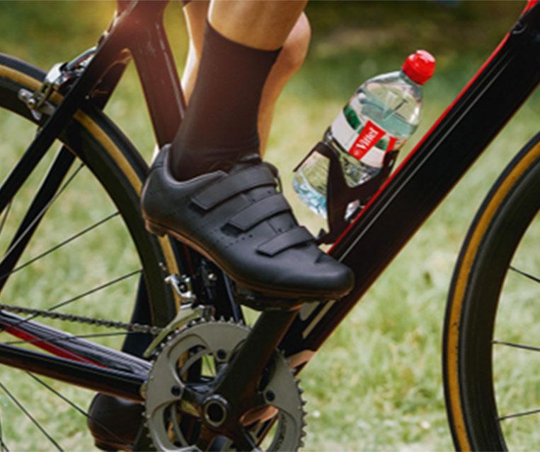 Cycliste avec bouteille d’eau Vittel sur son vélo